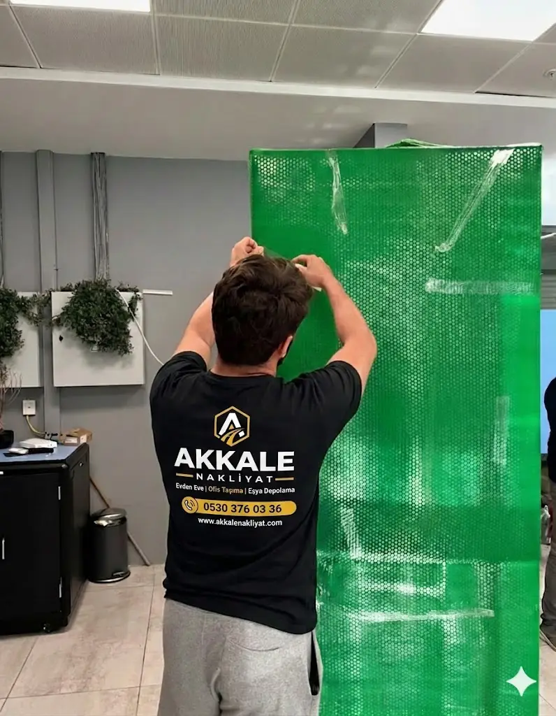 Akkale personeli mobilyayı baloncuklu naylonla profesyonelce paketlerken